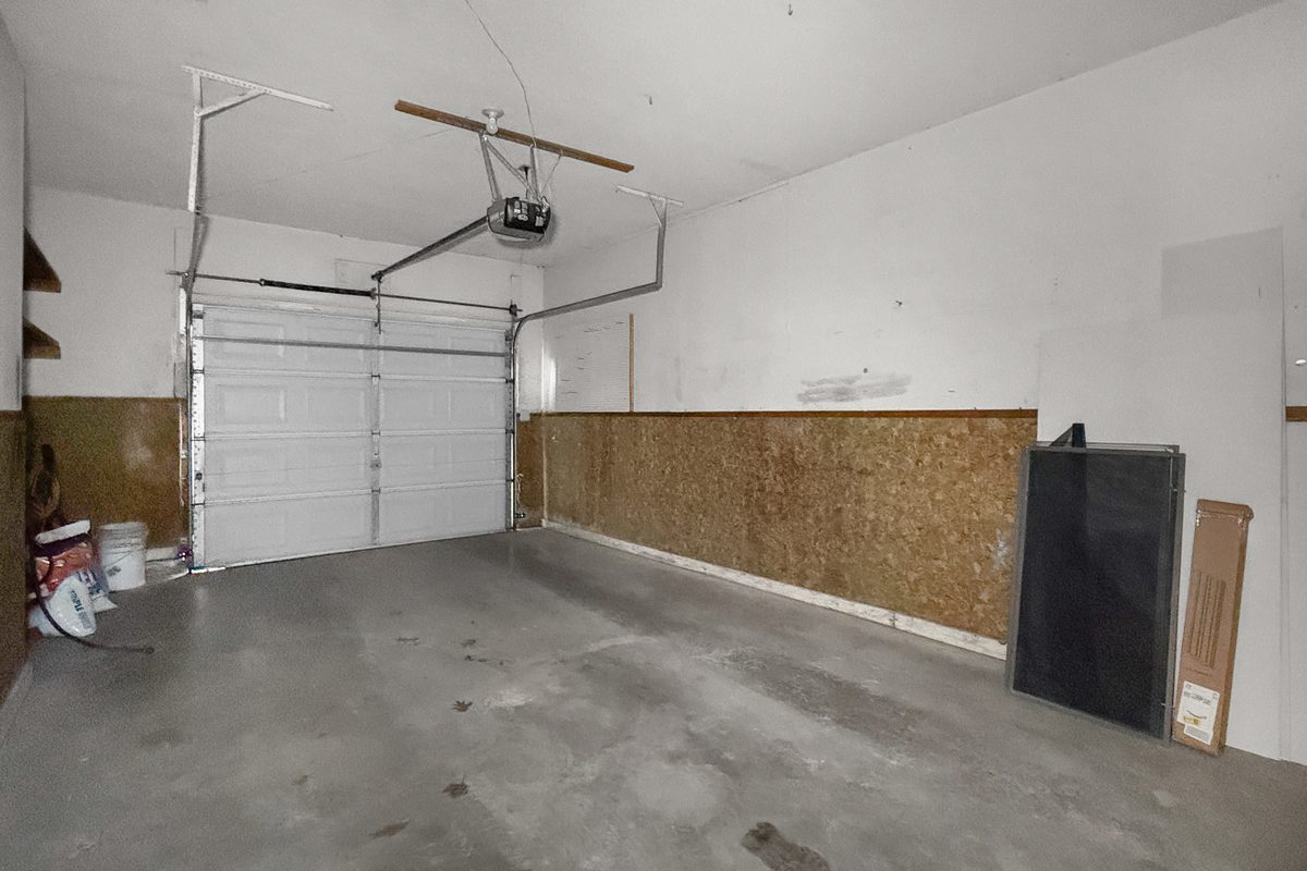 The inside of an attached one-car garage in a townhome, with the overhead door closed.